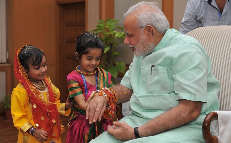 Women and children tie Rakhi on PM’s wrist on the occasion of Raksha Bandhan
