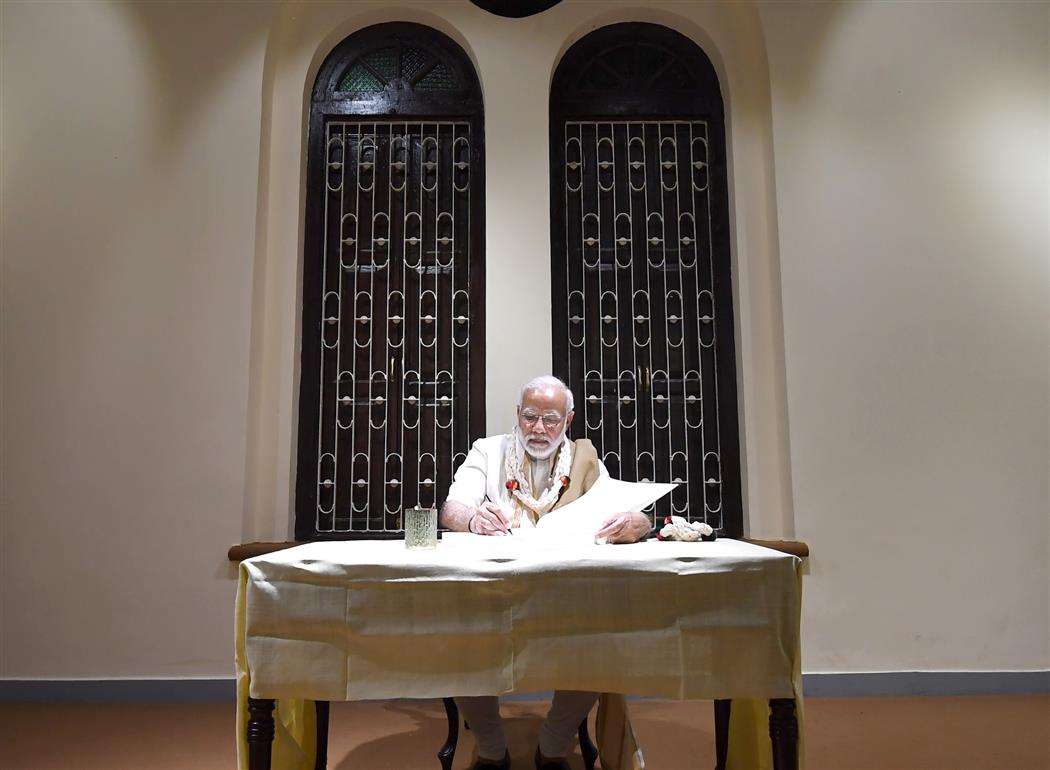 The Prime Minister, Shri Narendra Modi signing the visitors’ book after visiting the Mahatma Gandhi Museum, in Rajkot, Gujarat on September 30, 2018.