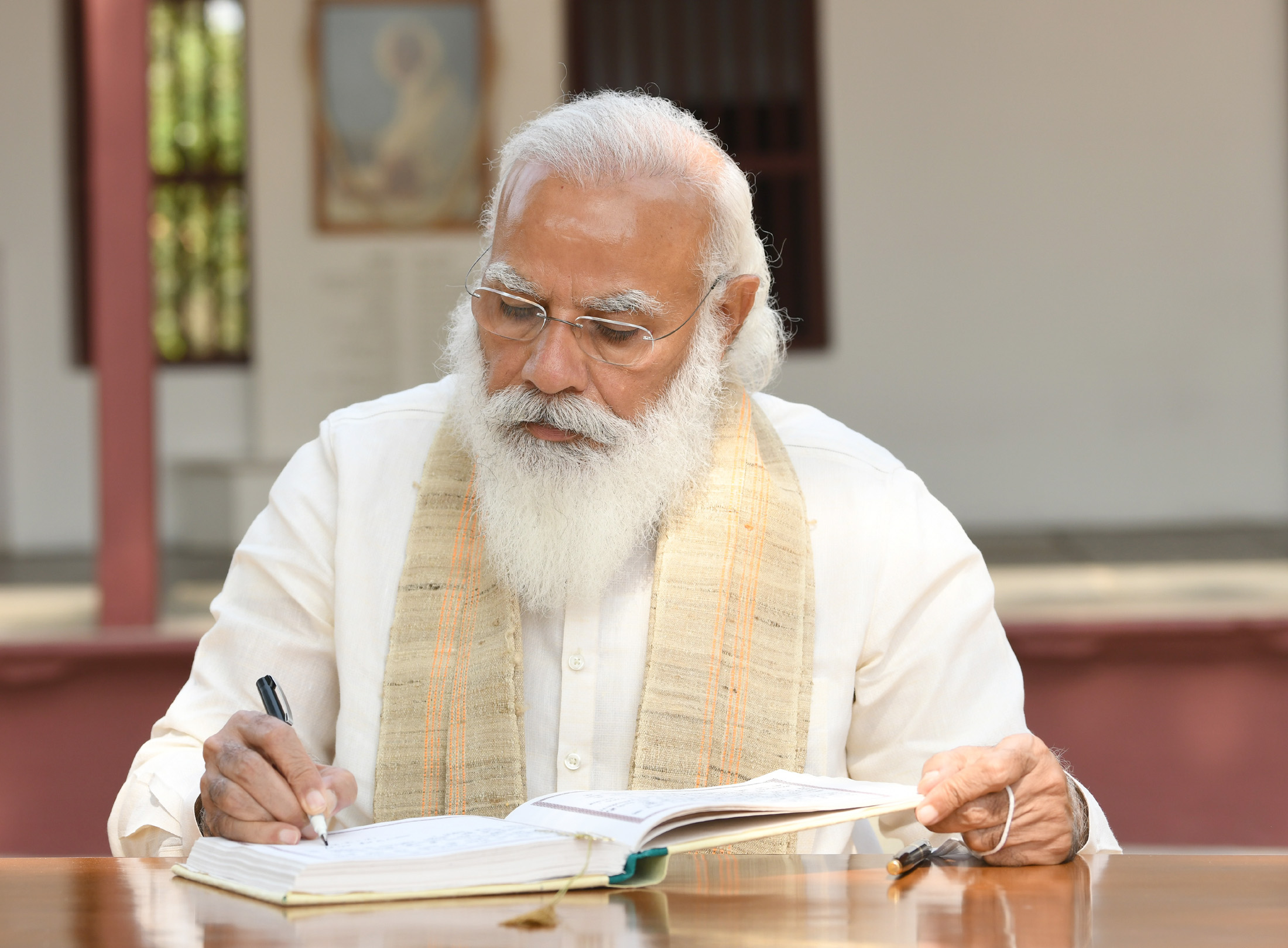The Prime Minister, Shri Narendra Modi signing the visitors book at Sabarmati Ashram, in Ahmedabad, Gujarat on March 12, 2021.